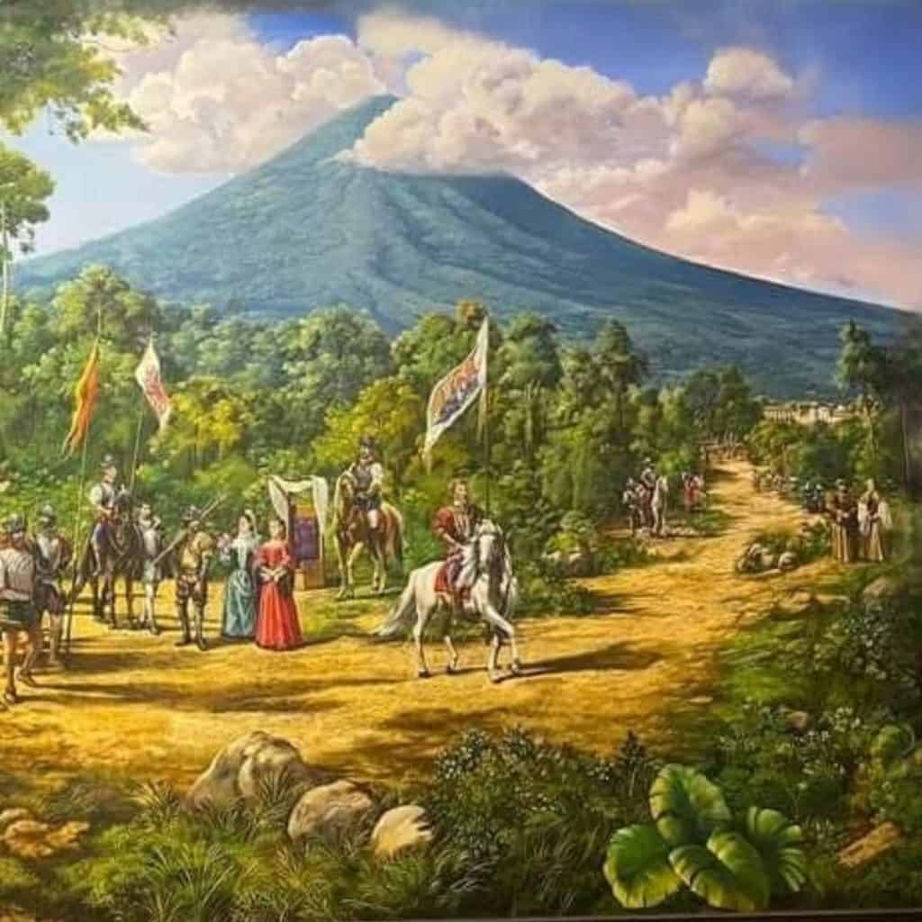 Paisaje volcánico con pintoresca escena histórica de caballeros y personajes en un entorno natural, representando cultura y tradición en un contexto latinoamericano. – SoyMigrante.com REVISTA