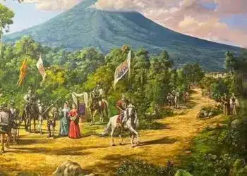 Paisaje de un volcán activo rodeado de naturaleza verde y marcado por una escena histórica con caballeros a caballo y personajes en vestimenta tradicional, promoción para la comunidad migrante en Guatemala.