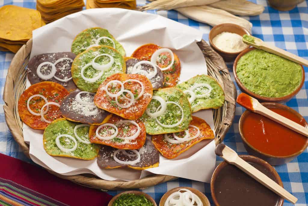 Coloridos tacos mexicanos con salsas tradicionales y guarniciones en un puesto callejero. Cocina auténtica mexicana, Perfectas para amantes de la comida callejera y sabores tradicionales. – SoyMigrante.com REVISTA