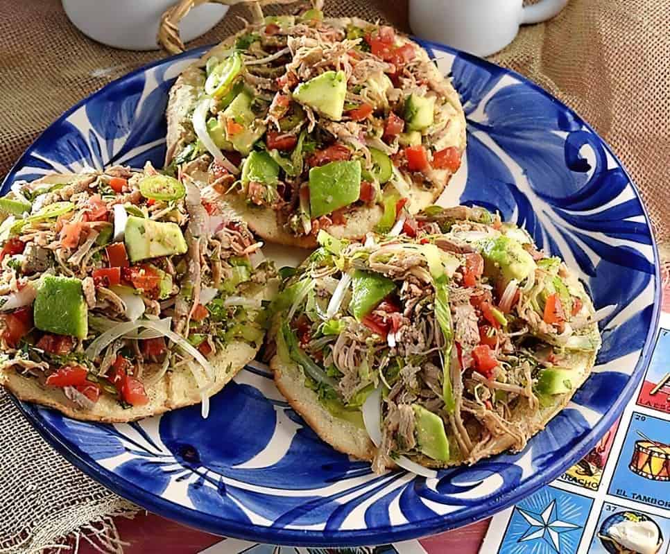 Tacos de pan con pollo desmenuzado, aguacate, tomate, cebolla y verduras frescas en plato típico mexicano, comida tradicional, ideal para desayuno o almuerzo saludable. – SoyMigrante.com REVISTA
