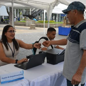 Tarjeta de empadronamiento en evento migrante, atención en mesa de registro, proceso de inscripción para migrantes, documentación oficial, asesoría migratoria, servicio para comunidad migrante, atención en el lugar.