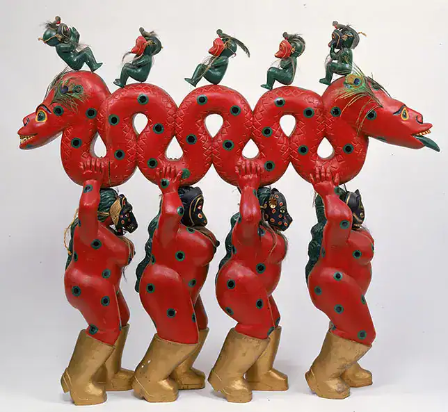 Coloridos muñecos tradicionales de dragón y personajes en una exhibición cultural, representando la riqueza de la cultura china y su influencia en festividades, ideal para artículos sobre cultura y migrantes.