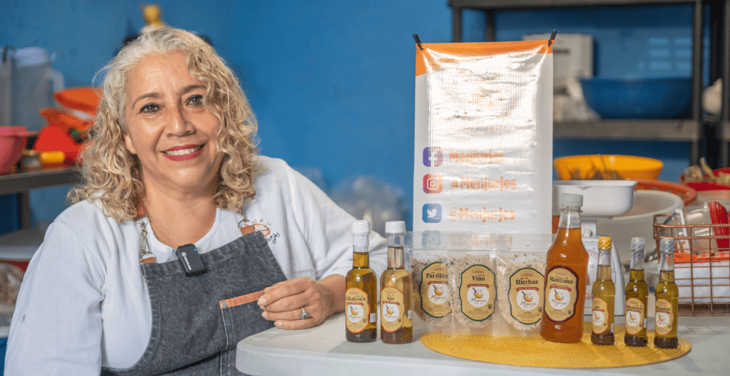 Aceite de hierbas y especias naturales en frascos con mujer que presenta productos en la cocina. – SoyMigrante.com REVISTA