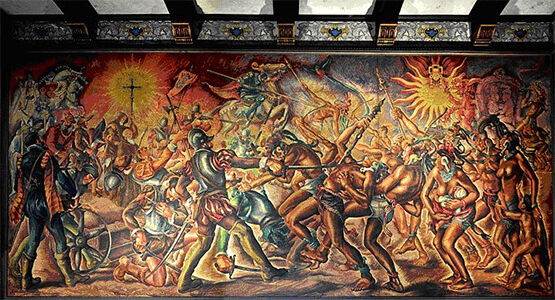 El choque de culturas presenta una dramática escena: la muerte del héroe nacional Tecún Umán. Mural de Alfredo Gálvez Suárez en el Palacio Nacional de la Cultura de Guatemala. – SoyMigrante.com REVISTA