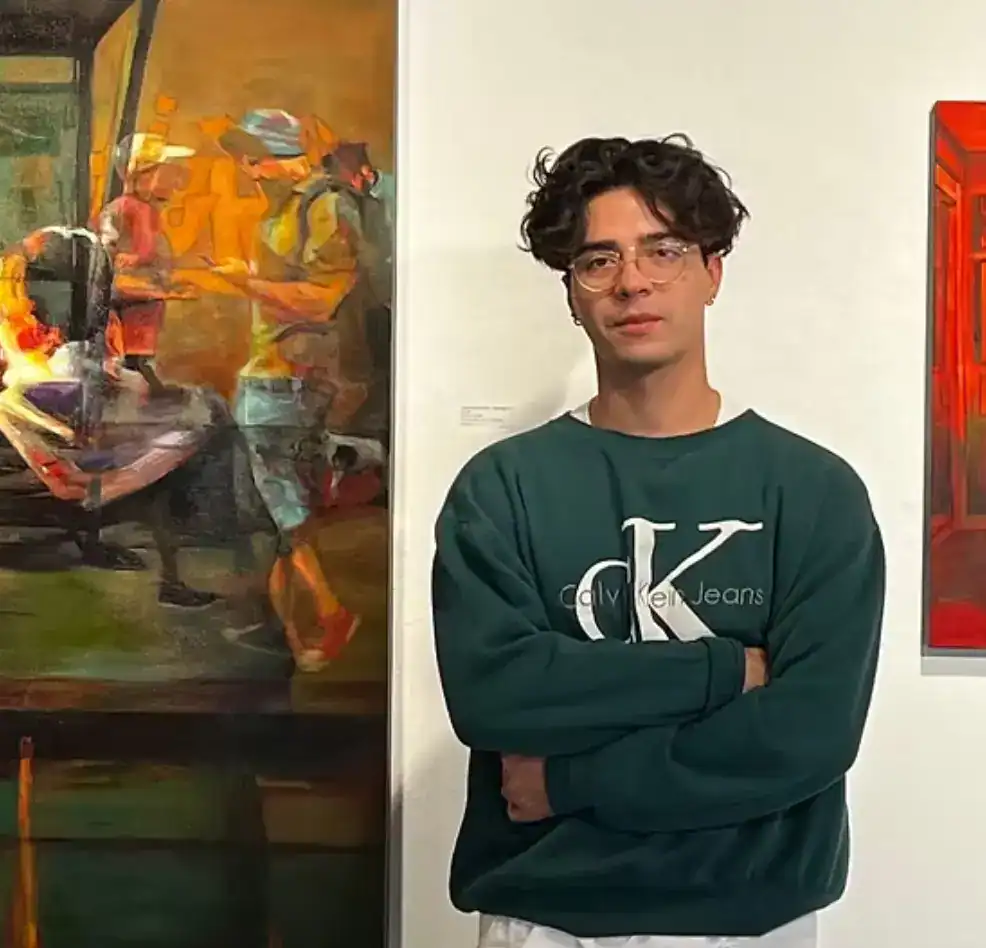 Joven en exposición de arte contemporáneo en SoyMigrante.com REVISTA, mostrando fotografía de un joven en galería de arte. – SoyMigrante.com REVISTA