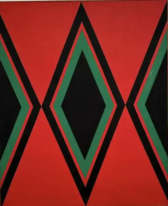 Valla decorativa con patrón geométrico en colores rojo, negro y verde, ideal para espacios culturales y artísticos. Diseño moderno y llamativo para paredes y mobiliario. – SoyMigrante.com REVISTA