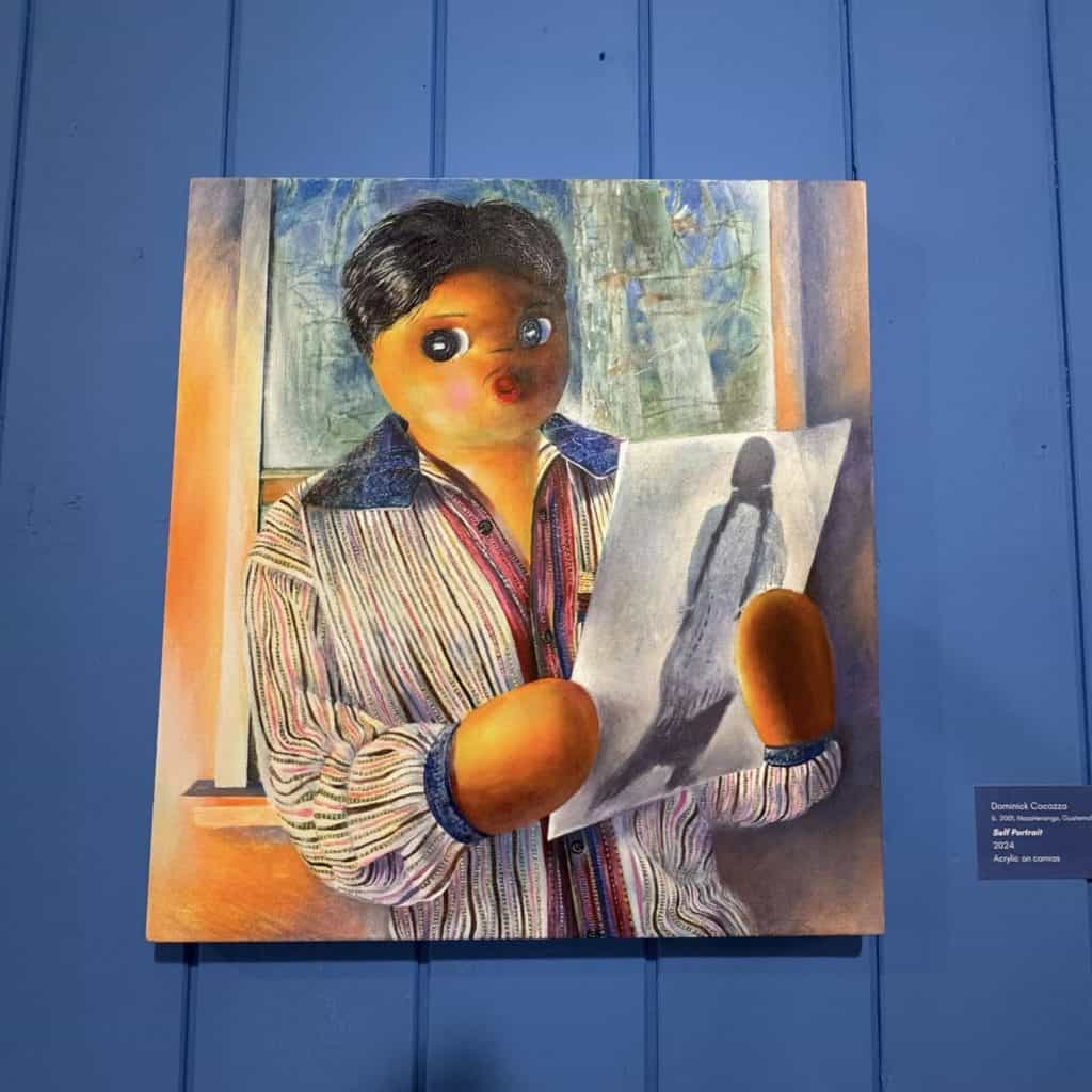 Autorretrato de Dominick Cocozza en la forma de un muñeco quitapenas, con lo cual reafirma su búsqueda de raíces de identidad maya en un entorno intercultural. (Foto Nacho Méndez) – SoyMigrante.com REVISTA