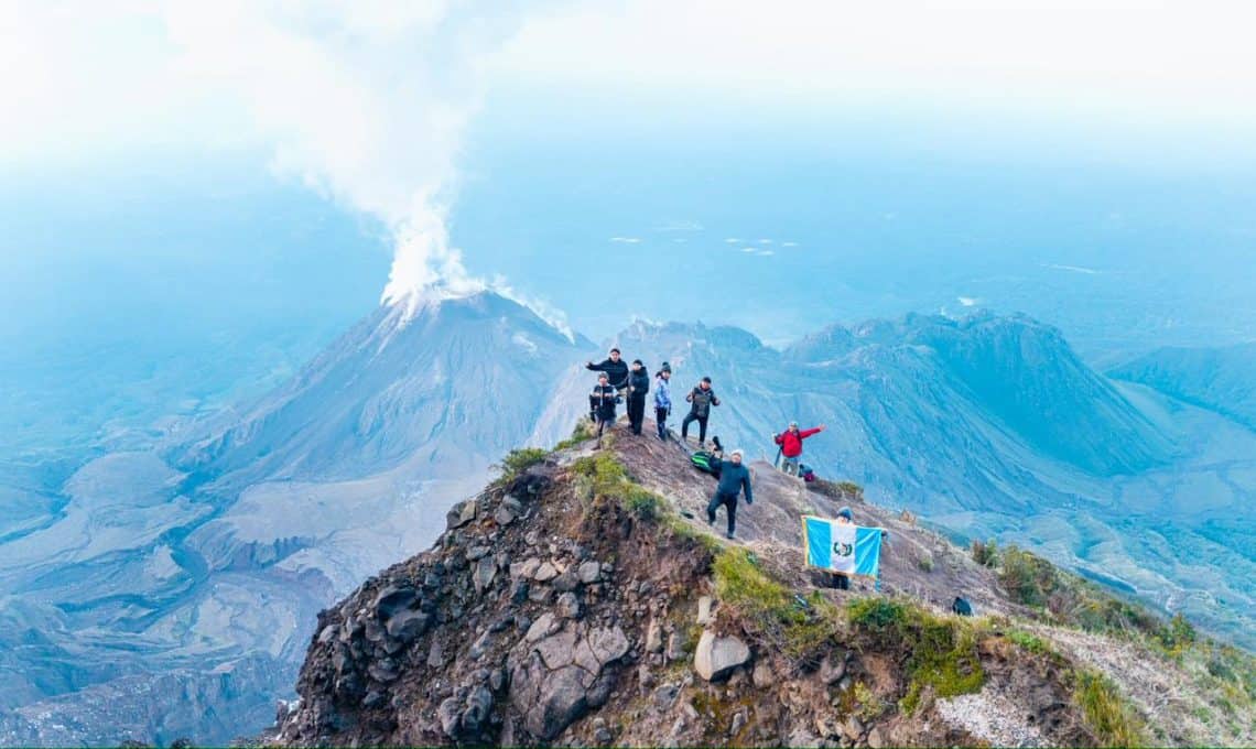 En cualquier escalada volcánica es muy conveniente viajar en compañía, ir bien abrigados, llevar hidratación y equipo adecuado si se piensa acampar. El grupo de Marcos Zárate llevaba hasta la bandera. Al fondo, el volcán Santiaguito. (Foto Marcos Zárate) – SoyMigrante.com REVISTA