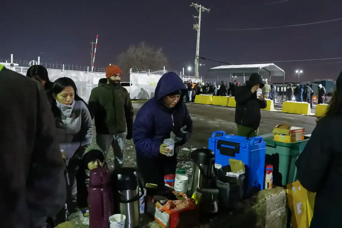 Voluntarios llegan a dar café y alimentos a quienese hacen fila en las afueras del centro de detención de migrantes Delaney, en Newark, New Jersey. Foto Alex Krales / The City – SoyMigrante.com REVISTA