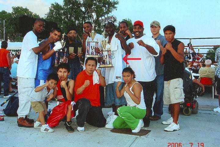 "20 años no es nada" dice la canción, pero sí son mucho. En esta fotografía aparece Esaú Diéguez, de camina roja, junto a varios jóvenes a los que entrenaba en boxeo para mantenerlos libres de riesgos en la calle. Entre ellos está un joven Terrence Crawford, señalado con una flecha. Fotografía en Omaha, Nebraska. Los pupilos de Diéguez muestran sus trofeos. – SoyMigrante.com REVISTA