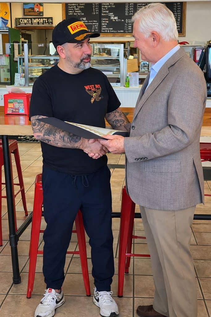 El alcalde de Saratoga Springs John Safford, entrega a Mario Cárdenas, la declaratoria oficial del 10 de marzo como el Día de West Ave Pizza. (Fotografía cortesía Mario Cárdenas)