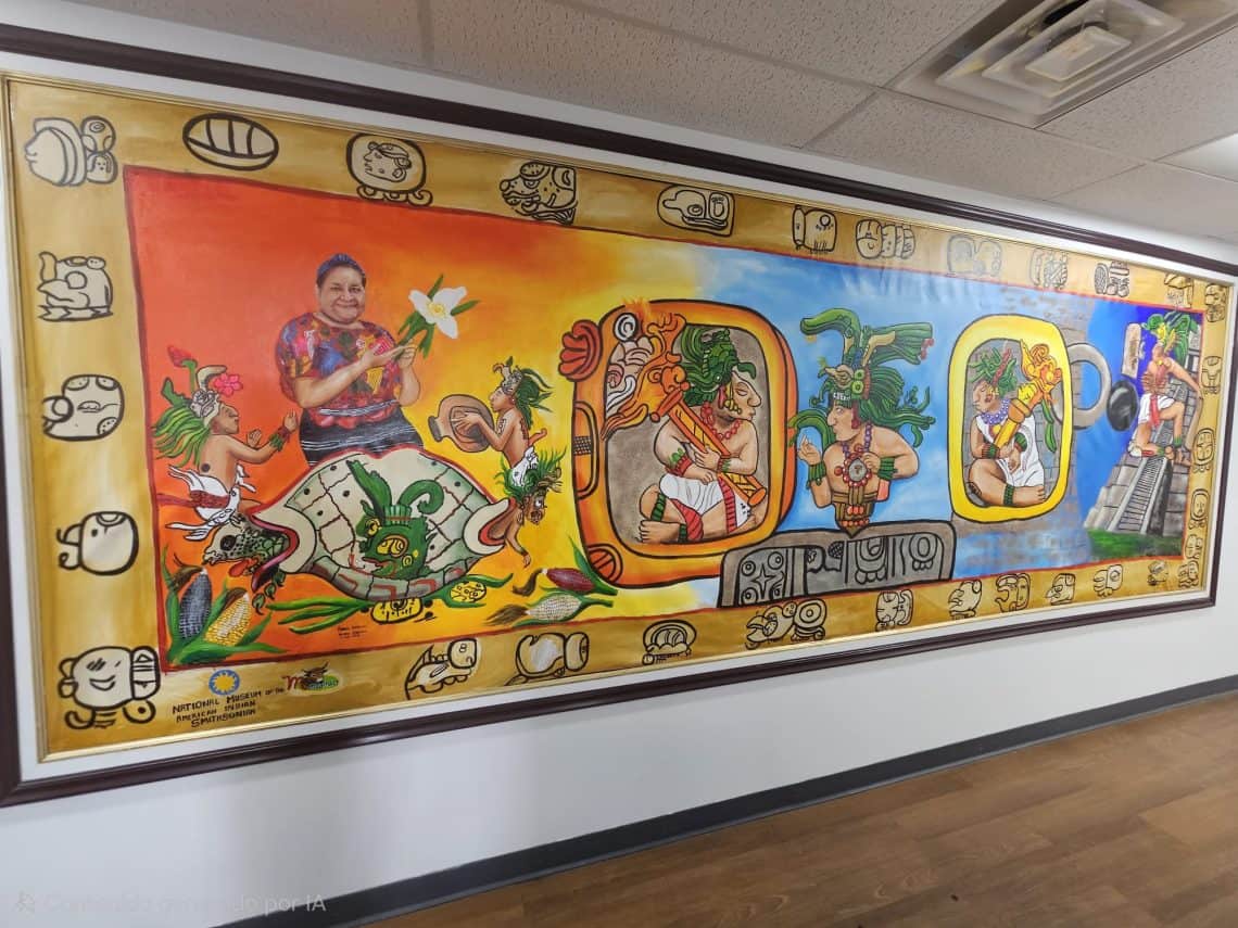 El mural inicia con la figura de la tortuga símbolo de la creación de cuyo caparazón emerge el Dios del Maíz. Las mazorcas aluden a los cuatro puntos cardinales Tambien aparece, simbólicamente el retrato de Rigoberta Menchú, Premio Nobel de la Paz 1992, como símbolo de diálogo, derechos humanos y orgullo maya guatemalteco. En el centro se representan tres ancestros mayas vinculados al ciclo de la Tierra, el Sol y la Luna. (Fotografía Consulado de Guatemala en Maryland)