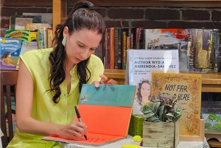 Nydia Armendia Sanchez, de madre guatemalteca y padre español, firma libros durante una presentación en Estados Unidos.