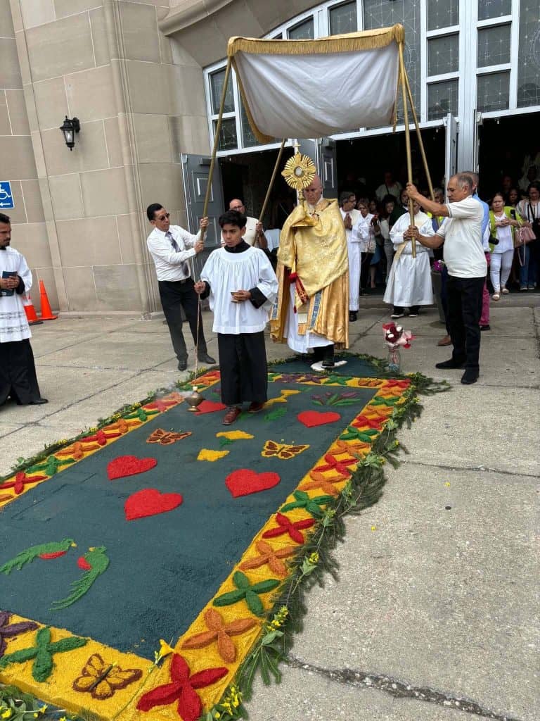 El Rey de Reyes y Señor de Señores sale en la Procesión de Procesiones, en la parroquia Nuestra Señora de la Merced en Aurora, Illinois, al norte de Chicago. El sacerdote porta la custodia y pasa sobre la alfombra guatemalteca en el día de Corpus Christi, la tarde del domingo 7 de junio.