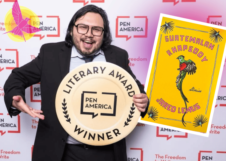 Smiling man in a suit holding a large circular 'Literary Award Winner' plaque with the Pen America logo; backdrop features 'The Freedom to Write'.