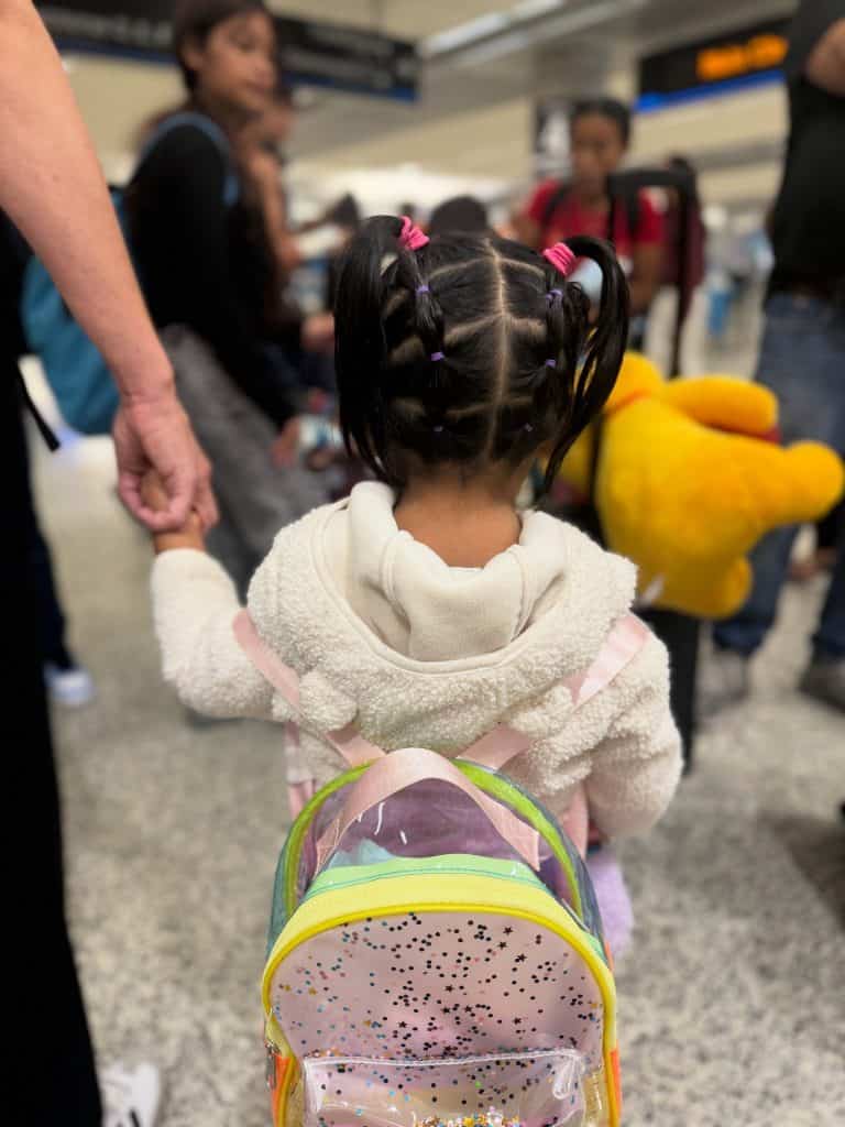 Su tía le trenzó el pelo a la pequeña Cristina, de 3 años. Abordó un vuelo para reunirse con sus padres, deportados, a pesar que ella nació en Estados Unidos. (Foto Guatemalan Maya Center)
