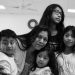 Mother with four children posing closely for a family portrait indoors (black and white).**