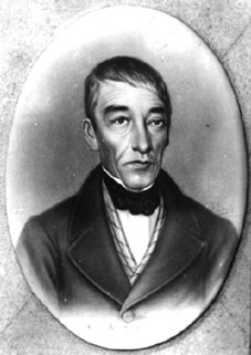 Formal black-and-white portrait of a 19th-century gentleman in a dark coat and bow tie, shown in an oval frame.