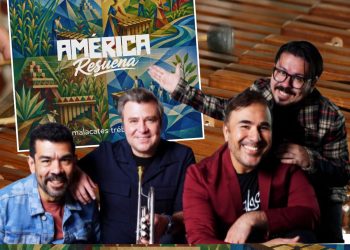 Four men posing with a bright geometric poster reading 'AMÉRICA Resuena' in a room with wooden benches in the background.