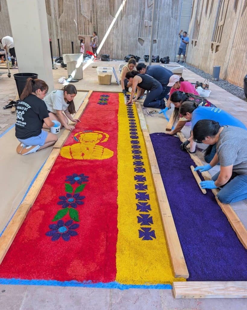 Los migrantes guatemaltecos aprendieron todo el proceso: desde el teñido del aserrín hasta la elaboración de moldes y las técnicas de aplicación del aserrín ya coloreado. Para muchos fue la primera vez que hacían una alfombra. El resultado fue esplendoroso. (Fotos Hilda de León Xavier)