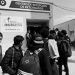 People with backpacks wait in a line outside the Centro de Recepción de Retornados at Guatemala's Instituto Guatemalteco de Migración.