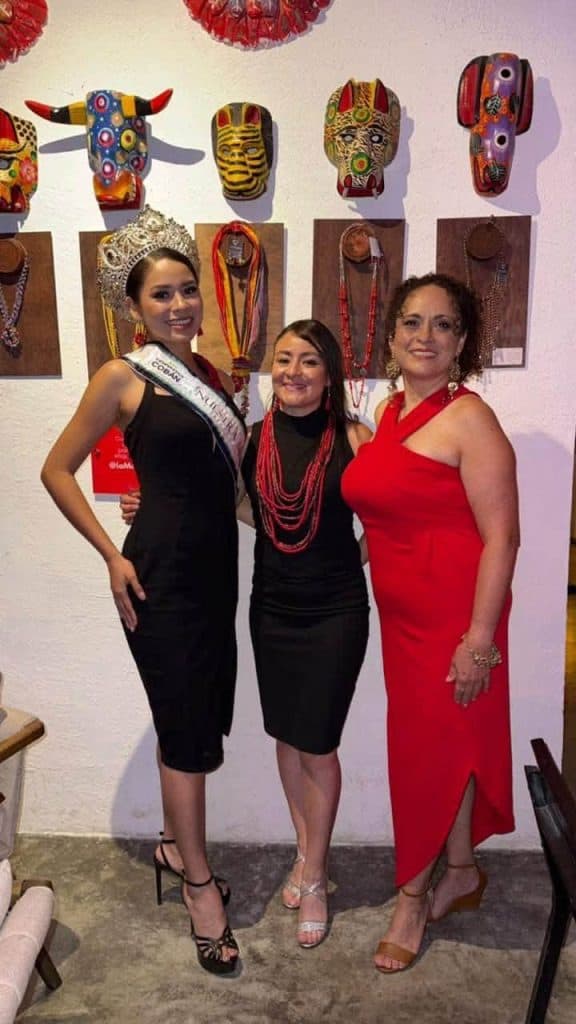 Las emprendedoras Francis Ericastilla, al centro y Victoria Figueroa, de rojo, junto a la señorita Monja Blanca 2026, en la inauguración de la exposición en galería La Morería, de San Juan Chamelco, Alta Verapaz, a pocos kilómetros de Cobán, donde ellas empezaron vendiendo sus creaciones en un nailon en las aceras.