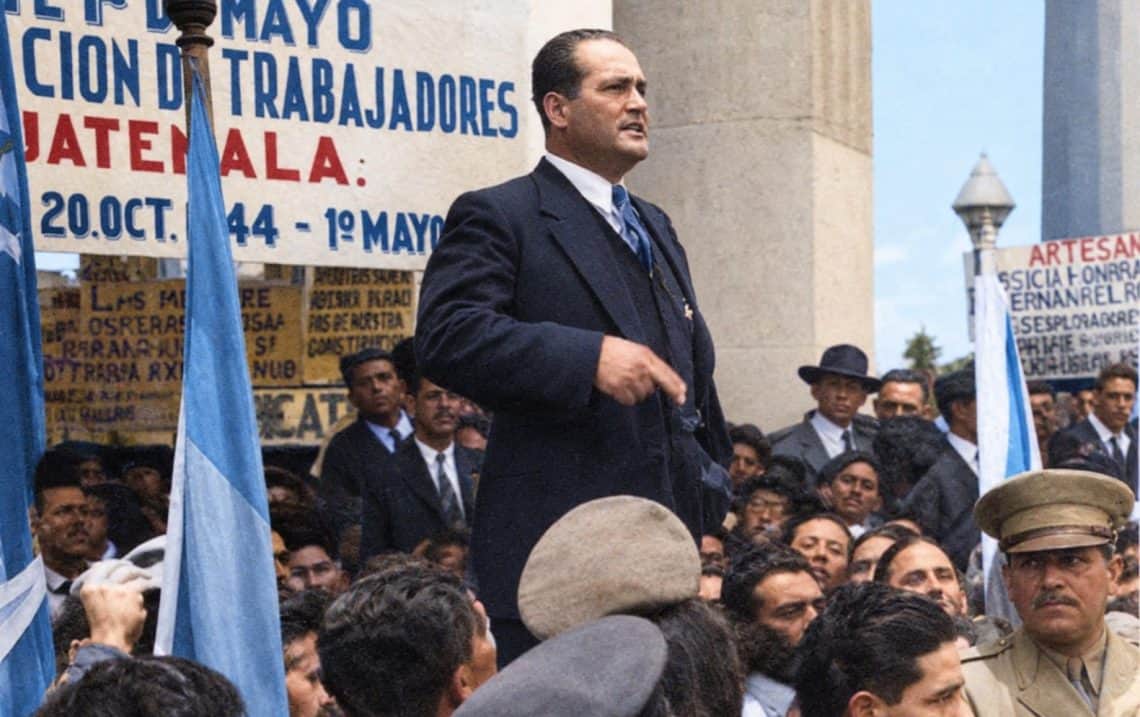 Ilustración coloreada a partir de una fotografía histórica de 1946 en la cual el presidente Juan José Arévalo dirige un discurso durante una conmemoración del Día del Trabajo.