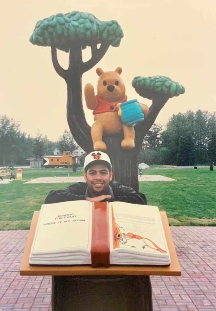 El guatemalteco Álvaro Cervantes posa junto a la escultura del árbol del personaje Winnie the Poo, que él creó para un parque de Ontario, Canadá, que aún se encuentra en ese lugar.