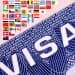 Close-up of a large blue 'USA' graphic with a row of small international flags above it on a pink background.