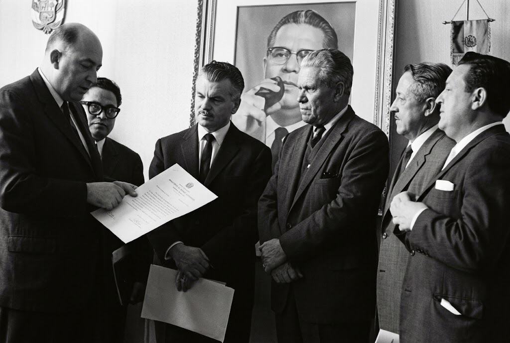 Fotografía restaurada digitalmente, del 10 de mayo de 1966, cuando el Congreso de la República notifica oficialmente al abogado Julio César Méndez Montenegro y al periodista Clemente Marroquín, que han sido oficialmente designados Presidente y Vicepresidente de la República, para el período 1966-1970. Habían pasado dos meses desde las elecciones. En el cuadro de atrás aparece Mario Méndez Montenegro, quien iba a ser candidato presidencial pero fue asesinado el 31 de octubre de 1965.