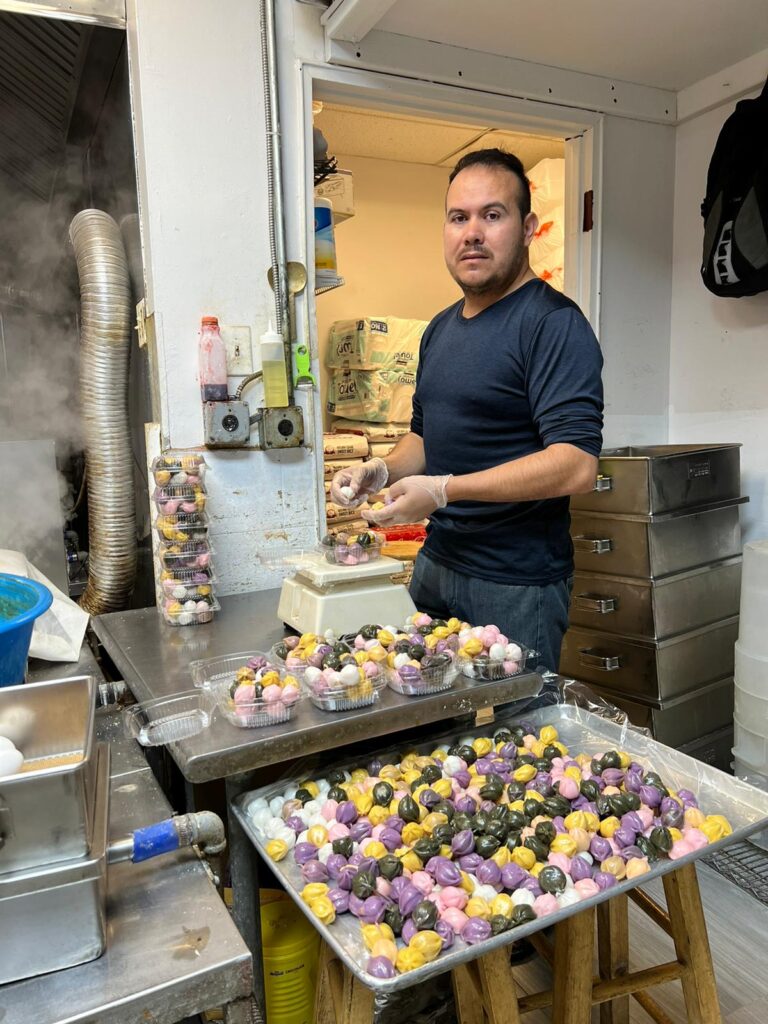 El migrante guatemalteco Leonel García en plena faena de preparación de pastelillos asiáticos