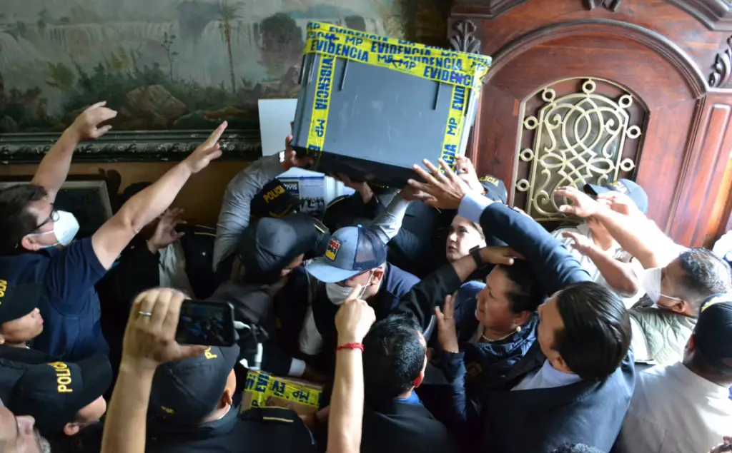 Esta fotografía le ha dado la vuelta al mundo: momento en que fiscales del Ministerio Público, varios de ellos enmascarados, secuestran las actas electorales en la sede del Tribunal Supremo Electoral. Magistrados electorales intentan infuctuosamente detener la salda de las cajas. Esto nunca antes había ocurrido en la historia democrática de Guatemala. Foto TSE – SoyMigrante.com – SoyMigrante.com