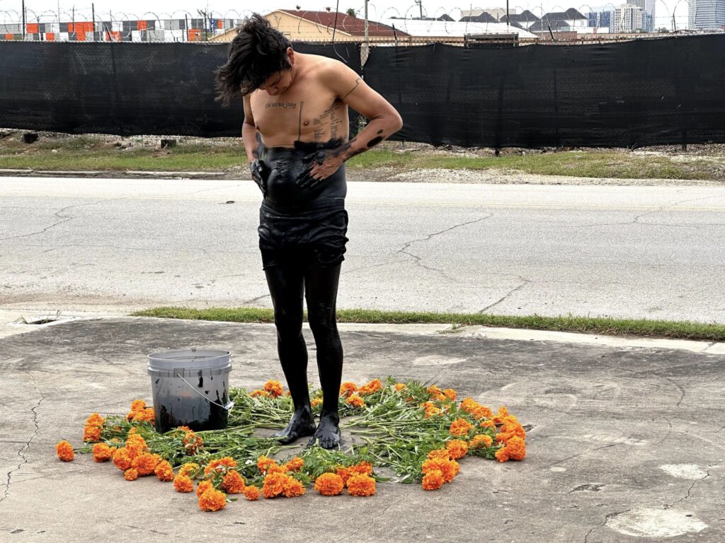 Rodeado de flores de muerto, Chavajay se cubre con óleo negro, para representar cómo deja su vida anterior y se muda a otra realidad.