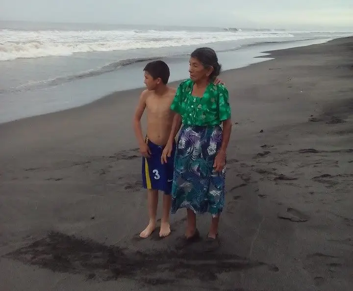 Samuel, cuando tenía 11 años, junto a su abuela, en una playa de la Costa Sur guatemalteca. Hoy la recuerda con cariño porque ya falleció y gracias al retorno obligado de sus padres pudo conocerla.