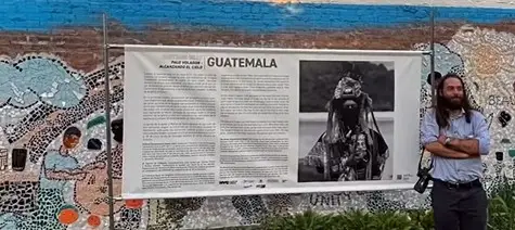 Santiago Billy, fotógrafo guatemalteco, junto a una de las imágenes y textos del Palo Volador que expone en Nueva York (Fotografía del instagram Bronx Documentary Center) – SoyMigrante.com – SoyMigrante.com