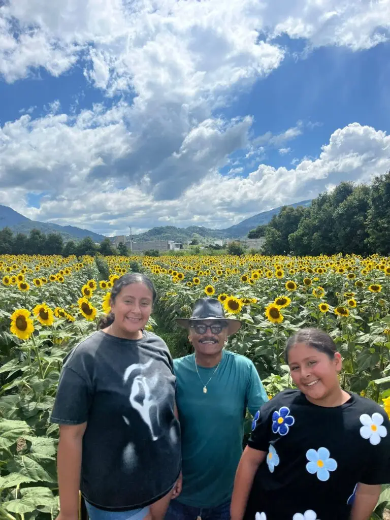 René acompañado de sus nietas en su visita al campo de girasoles.