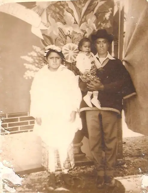 El vínculo sagrado del matrimonio y de la familia es uno de los grandes valores fundamentales de los Q'anjob'al. Fotografía de Lucía Marcos y Marcos Andrés junto a su hija Juana en la década 1970. Ella luce el tradicional Col ceremonial y él, la prenda masculina llamada Capixay. – SoyMigrante.com – SoyMigrante.com