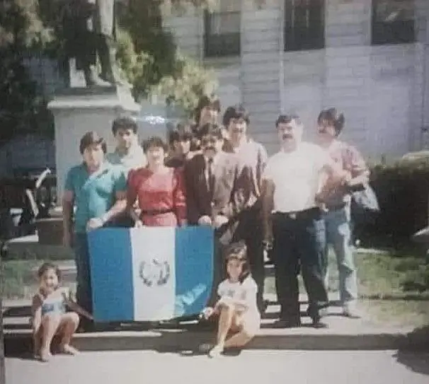 Fueron pocos guatemaltecos los que llegaron, pero llegaron. Fue un momento muy emocionante hacer el acto cívico con la bandera azul y blanco en Paterson, New Jersey aquel 1986. Carlos Horacio está de saco café y corbata, enmedio del grupo. – SoyMigrante.com – SoyMigrante.com