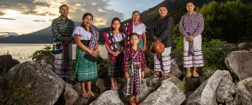 El artista Tz'utujil Juan Bautista Navichoc comparte esta fotografía de su archivo personal junto a su familia, tomada en San Pedro La Laguna, y al fondo se aprecia el Lago de Atitlán. Retrato tomado por Carlos Francisco Pop – SoyMigrante.com – SoyMigrante.com